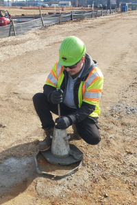 Field technician performing a concrete slump test during on-site materials testing