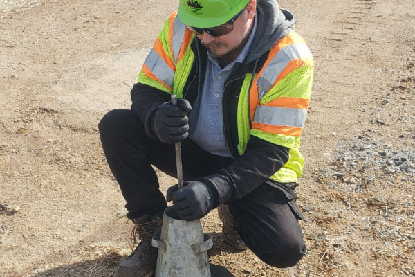 Field technician performing a concrete slump test during on-site materials testing