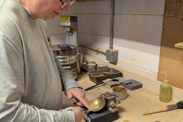 Technician performing soil testing in a construction materials laboratory using standard testing equipment