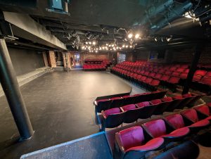 Interior theater space at Hanover Tavern with stage seating and performance lighting.