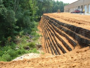 Reinforced soil retaining wall supporting a commercial development and stabilizing a steep slope.