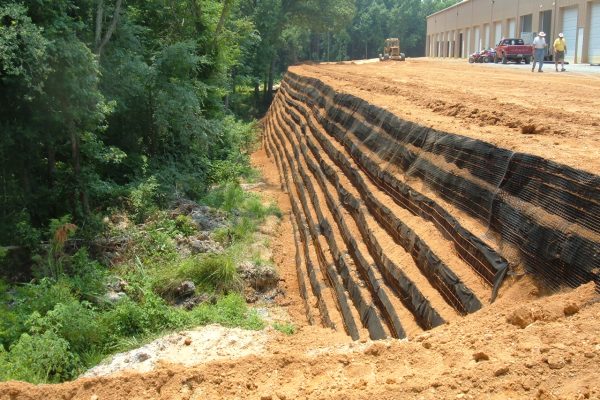 Reinforced soil retaining wall supporting a commercial development and stabilizing a steep slope.