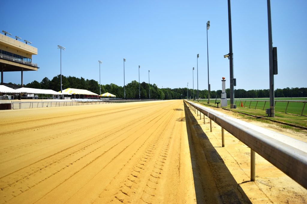 The dirt racing surface at Colonial Downs Racetrack in New Kent County, Virginia, viewed alongside the grandstand.