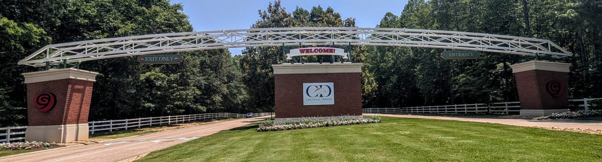 The entrance to Colonial Downs Racetrack in New Kent County, Virginia, featuring the main welcome arch, landscaped entrance, and Colonial Downs sign.