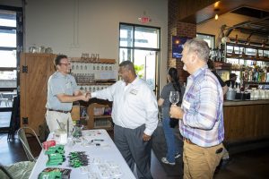 Guests shaking hands and socializing at Zannino Engineering’s 35th anniversary celebration at River City Roll.
