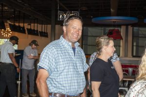 Smiling guest in a blue plaid shirt among attendees at Zannino Engineering's 35th anniversary celebration.