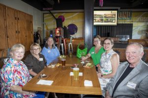 Six guests seated around a table enjoying food and conversation at Zannino Engineering’s 35th anniversary celebration.