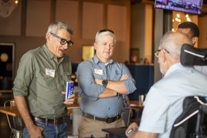 Three guests engaged in conversation at Zannino Engineering’s 35th anniversary celebration at River City Roll.